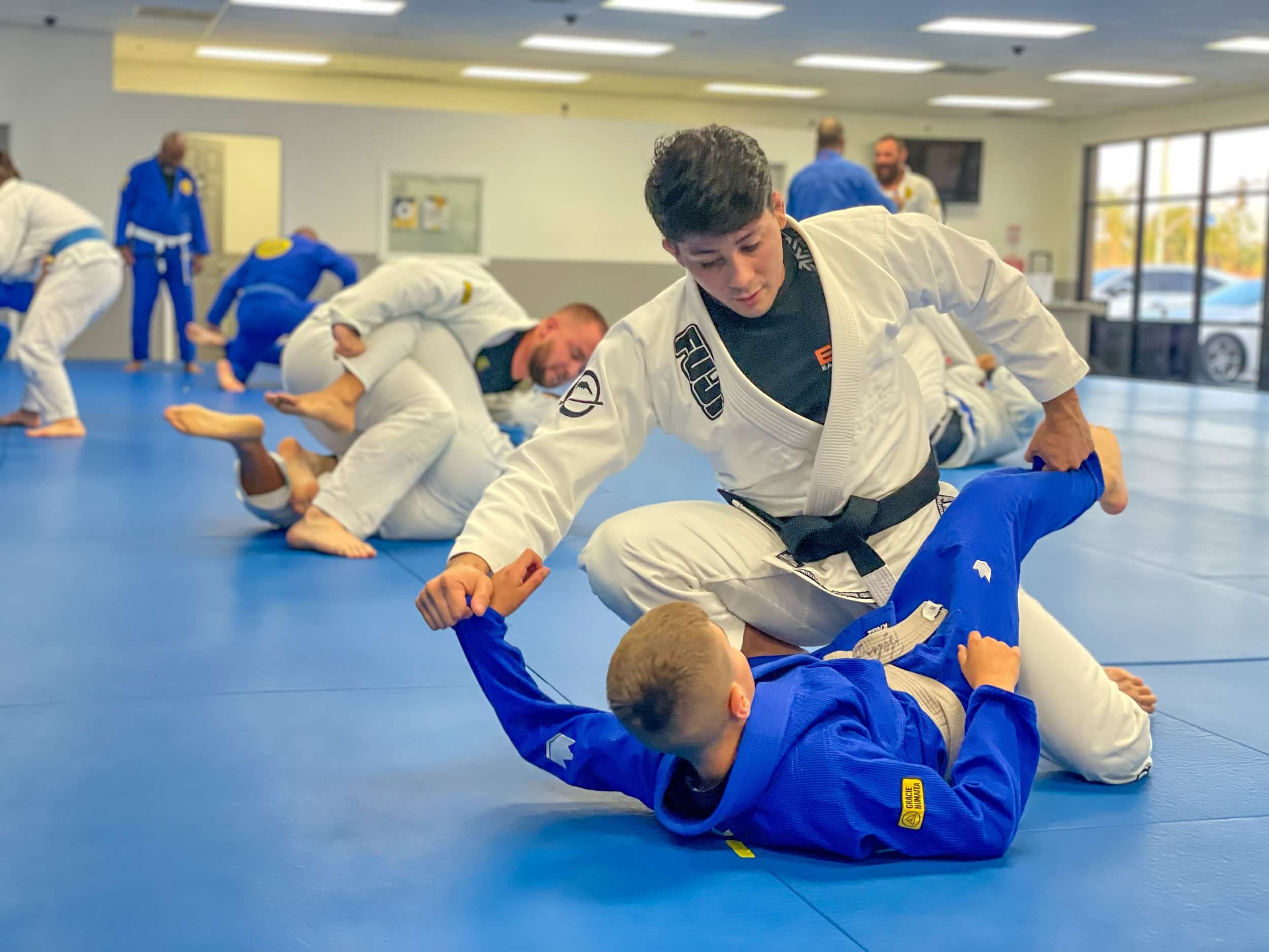 092 Brazilian Jiu-Jitsu Class in blue and white gi sparring on the mat